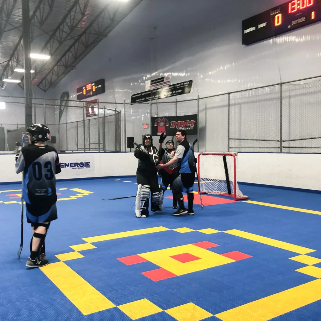 Match de hockey en salle, joueurs et gardien posant.